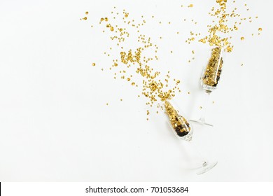 Glasses With Golden Confetti Tinsel On White Background. Flat Lay, Top View Celebrate Party Concept.