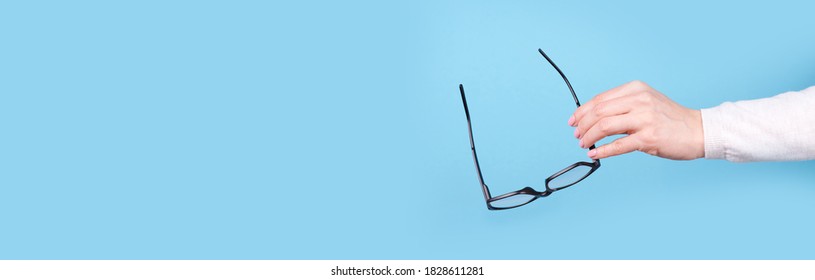 Glasses In A Hand On A Blue Background, Copy Space Template, Banner.