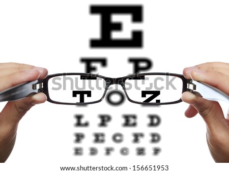 Glasses in hands in front of eye test