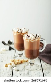 Glasses of hot chocolate with marshmallows on white wooden background - Shutterstock ID 269691698