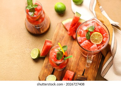 Glasses and jug of tasty cold watermelon lemonade on table