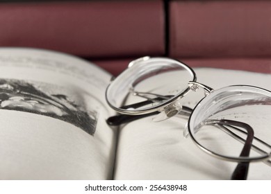 Glasses lie on the opened book.