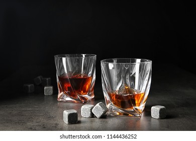Glasses with liquor and whiskey stones on table