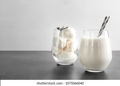 Glasses With Milk Shake And Tasty Vanilla Ice Cream On Grey Table