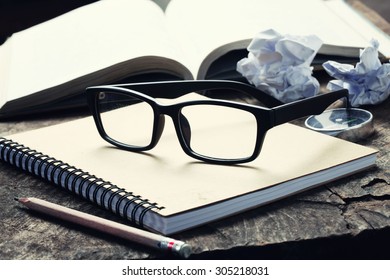 Glasses with note book on wood background.Vintage Style. - Powered by Shutterstock