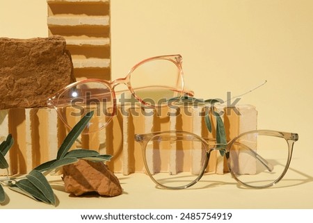 Glasses and olive tree branches on stones on beige background