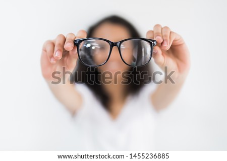 Glasses - optician showing eyewear. Closeup of glasses, with glasses and frame in focus. Woman optometrist on white background.