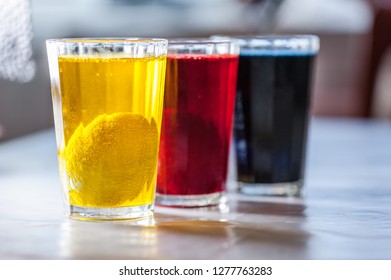 Glasses with paint for Easter eggs. Easter Egg decorating. Close up, soft focus. Step of painting process. Homemade.