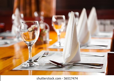 Glasses and plates on table in restaurant - food background