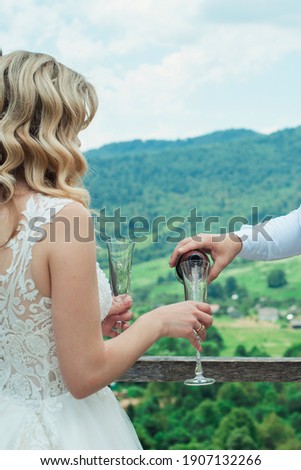 Glasses with red champagne drink. groom pouring wine. Happy newlyweds drinking. Loving couple created new family.