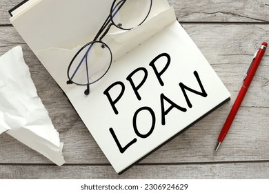 glasses and a red pen. Paycheck Protection Program PPP Loan text. on an open notebook - Shutterstock ID 2306924629