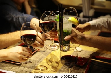 Glasses Of Red Wine Non-alcoholic Mojito Over The Table Close-up. Male And Female Hands With A Wedding Ring. Concept Friends Celebrate A Birthday Toast