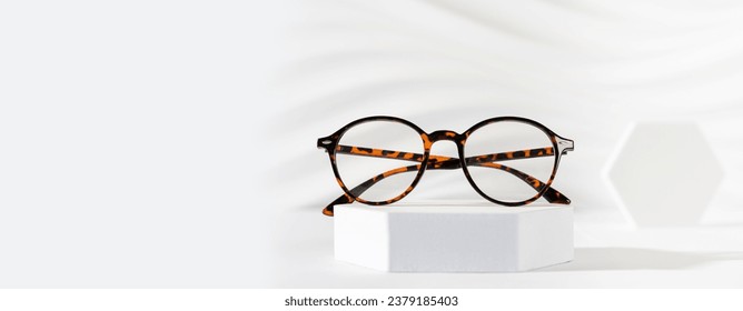 Glasses sale banner. Optic store sale-out offer. Trendy glasses in plastic frame on a podium on a white background. Copy space for text. For banner, web line. Optic store discount, promotion - Powered by Shutterstock