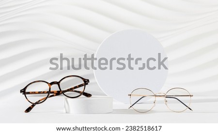 Glasses sale banner. Optic store sale-out offer. Trendy glasses in plastic and metallic frame on a podium on white background. Copy space. Banner, web line. Optic store discount, eyewear promotion