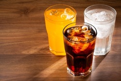 Glasses Of Soda Flavors Orange, Lemon And Cola.