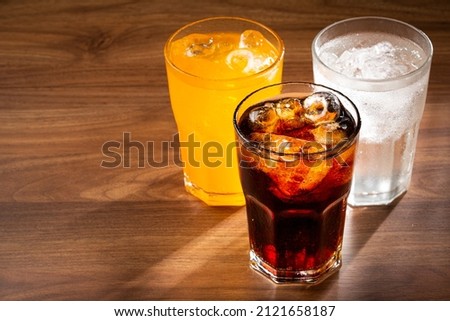 Glasses of soda flavors orange, lemon and cola.