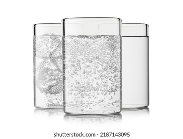 Glasses With Still And Sparkling Water With Ice Cubes And Bubbles On White.