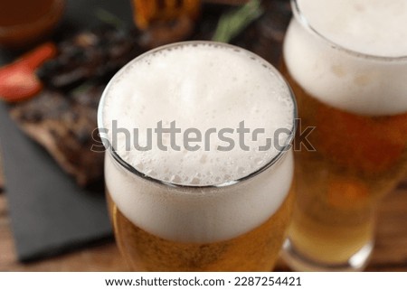 Glasses of tasty beer on table, closeup view
