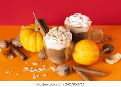 Glasses of tasty pumpkin latte with cinnamon and almond on colorful background - Powered by Shutterstock