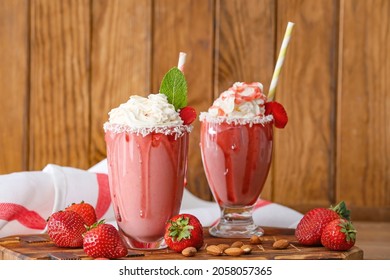 Glasses of tasty strawberry milkshake on table - Shutterstock ID 2058057365