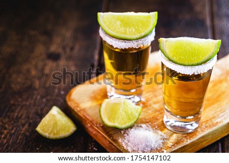 glasses of tequila, with lemon and salt. drink originating in mexico.
