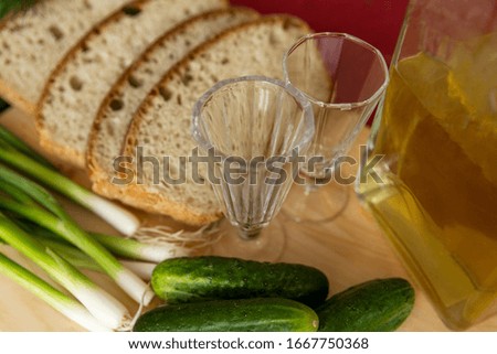 Glasses for vodka and fresh tomatoes, cucumbers and greens. Appetizing appetizer. Close-up.