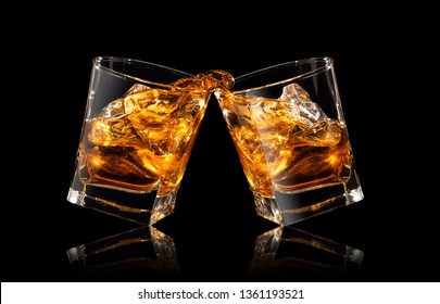 Glasses Of Whiskey Making Toast With Splashes On Black Background