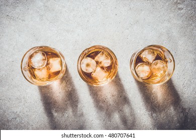 Glasses of whiskey on gray stone table