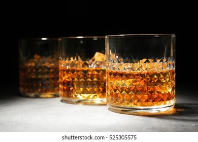 Glasses Of Whisky On Grey Textured Table Closeup