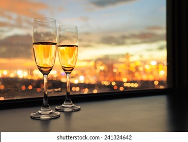 Glasses of white wine against sunset  - Powered by Shutterstock