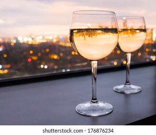 Glasses of white wine with city view - Powered by Shutterstock