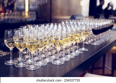 Glasses of white wine on bar counter, small focus depth, toned image