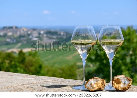 Glasses of white wine from vineyards of Sancerre  Chavignol appelation and example of flint pebbles soil, near Sancerre village, Cher, Loire valley, France.