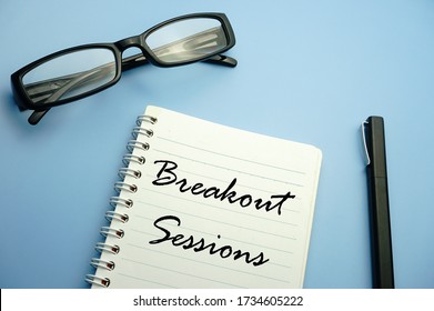 Glasses,pen And Notebook Written Breakout Sessions Over Blue Background.business Concept.