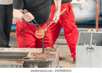 Glassmaker working on a glass bulb - Powered by Shutterstock