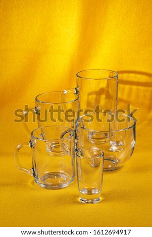 Glassware different in volume and shape on a bright yellow fabric