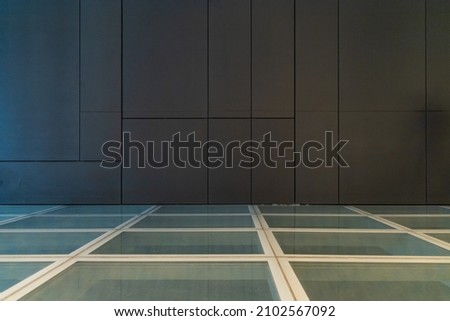 Glassy floor with big gray tiles on wall