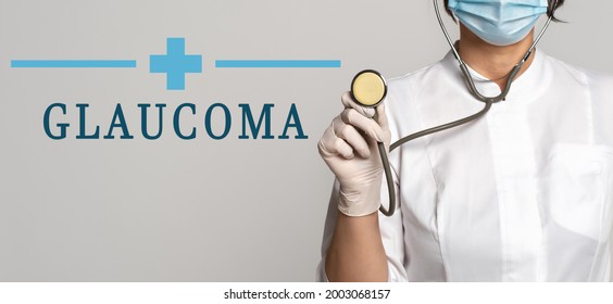 Glaucoma - Concept Of Text On Gray Background. Nearby Is A Cropped View Of Doctor In White Coat, Protective Face Mask And Stethoscope. Medical Concept