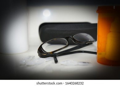 Glaucoma Halo Around Glasses Beside Prescription Vial. Heavy Vignette Simulating Glaucoma Vision Loss