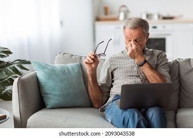 Glaucoma. Senior Man Taking Off Glasses Tired After Work On Laptop, Rubbing Nosebridge Having Eyesight Problems And Migraine Symptom Sitting On Couch At Home. Stress, Eyes Health Issues