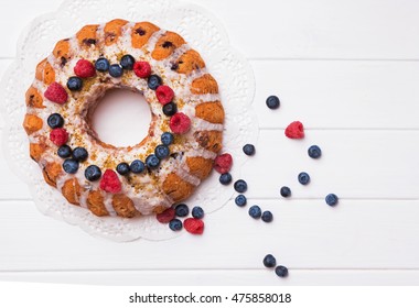 Glazed Bundt Cake With Berries On White Table, Top View