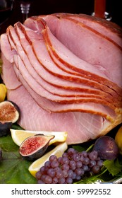 Glazed Delicious Whole Baked Honey Sliced Ham With Figs, Lemons And Champagne Grapes.