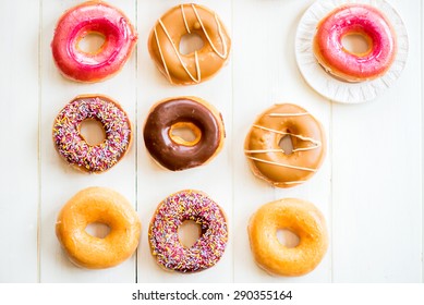 Glazed Doughnuts with colourful sprinkles and icing on white background - Powered by Shutterstock