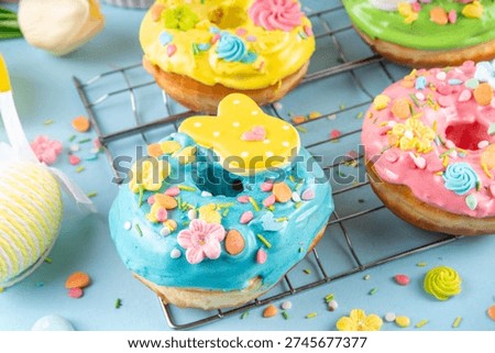 Glazed Easter Donuts, with pastel topping decorated with bunnies and eggs with colorful sugar sprinkles, soft and fluffy baked dessert for Easter holiday party