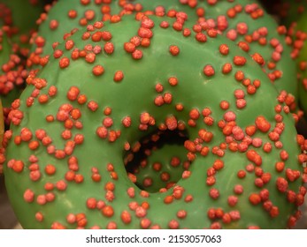 Glazed Green Doughnut With Red Sugar Crispy Sprikles On A Shop Window, Close Up View