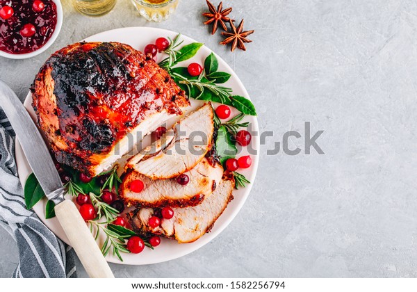 Glazed Ham with cranberry sauce.\
Roasted Holiday Pork with spices. Top view, copy\
space.