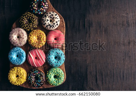 Glazed mini donuts on wooden background with blank space 
