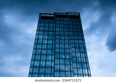 Glazed office space against a stormy cloudy sky - Powered by Shutterstock