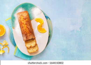 Glazed Orange Pound Cake Partly Sliced And Fresh Citrus Fruits.Top View, Blank Space