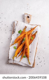 Glazed And Roasted Young Red Carrots On A Piece Of Baking Paper, White Background